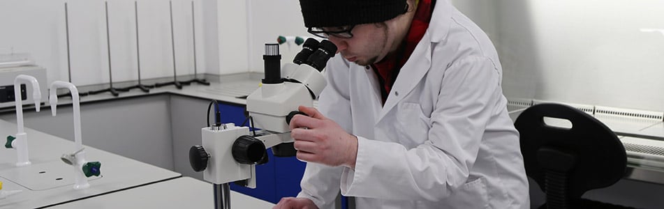 Science student looking through a microscope